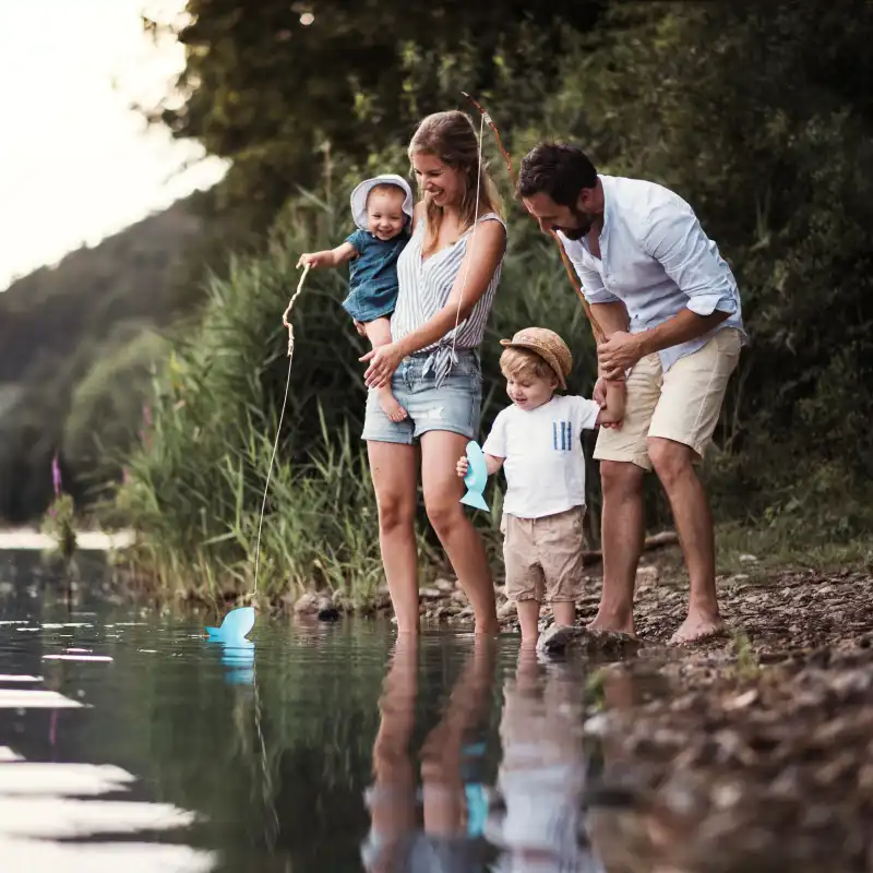 Eine Familie steht an einem Flussufer Eine Familie steht an einem Flussufer